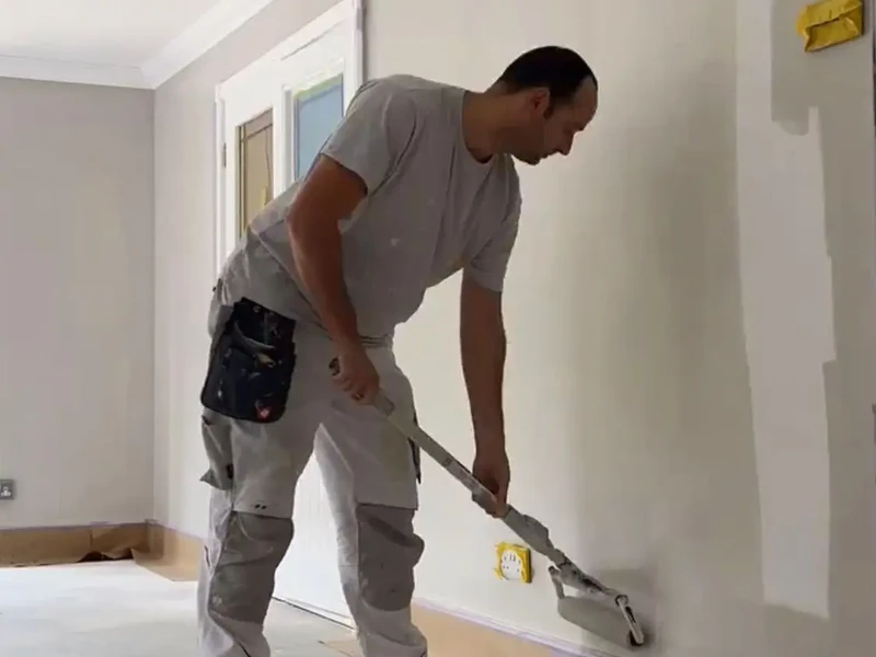 Martin Cole painting an interior wall